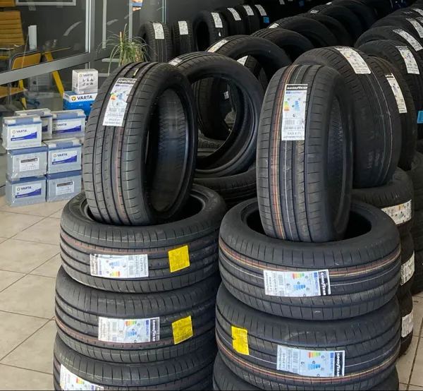 Akü Lastik Servis deposunda ebatlarına göre istiflenmiş lastikler ve raftaki aküler